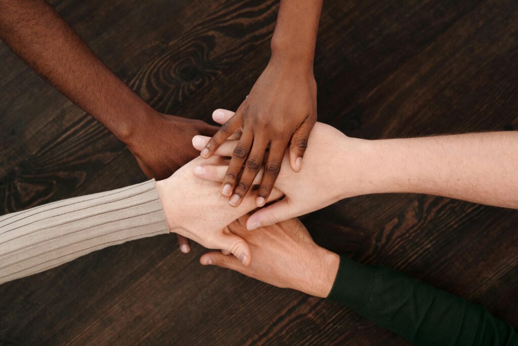 various hands joining together in teamwork pose